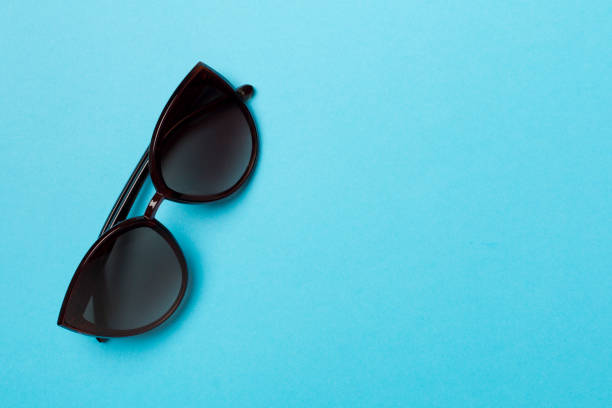 istock Sunglasses on color background, top view 1464201244