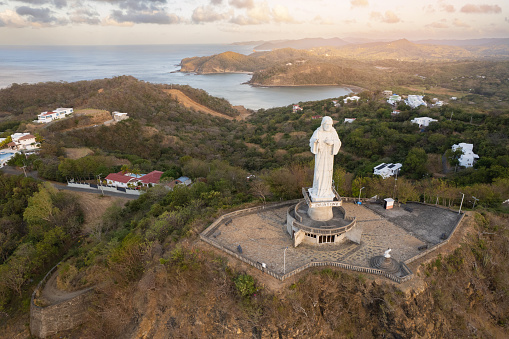 Harbor in pacific ocean with jesus statue front aerial drone view