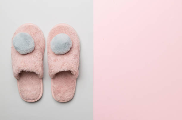 istock Soft pink slippers on color background, top view 1464202714