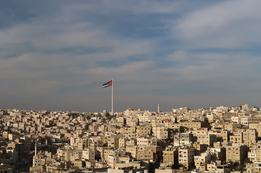 Bandera jordana sobre el horizonte de Amman, Jordania photo