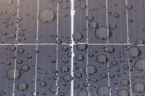 Green energy. Solar panels with raindrops close up. The use of waterproof solar panels in difficult environments, the production of green energy