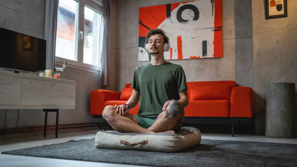 istock One man doing guided meditation yoga self care practice at home 1464208581