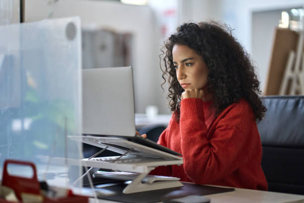 busy latin female worker working on laptop thinking analyzing online data. - 培訓班 圖片 個照片及圖片檔