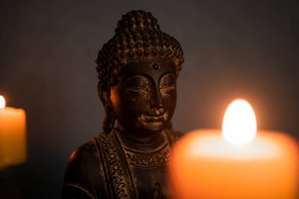 istock Statue of Buddha and blurred candle lights 1464214978
