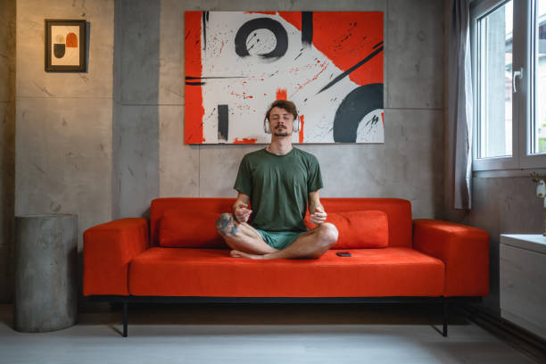 istock One man doing guided meditation yoga self care practice at home 1464215336