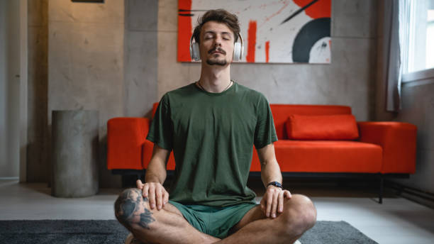 istock One man doing guided meditation yoga self care practice at home 1464215385