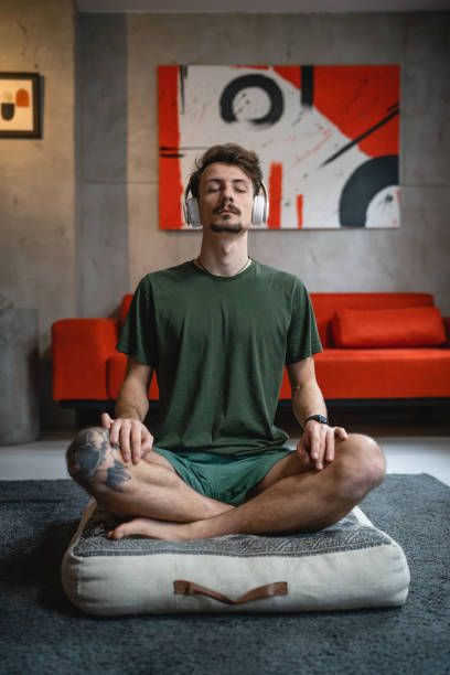 istock One man doing guided meditation yoga self care practice at home 1464215547
