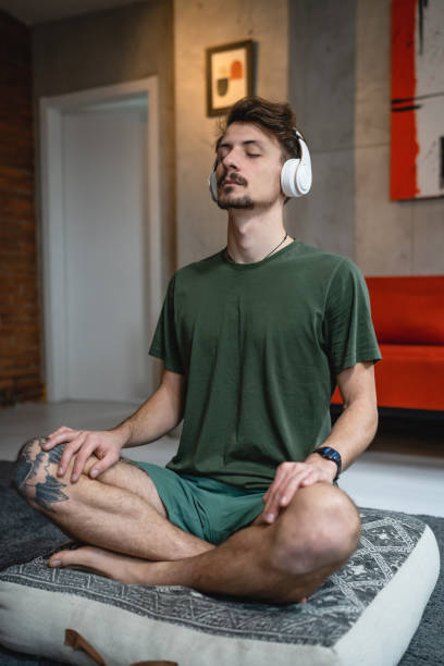 istock One man doing guided meditation yoga self care practice at home 1464215852