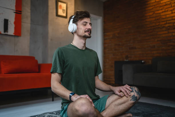 istock One man doing guided meditation yoga self care practice at home 1464215898