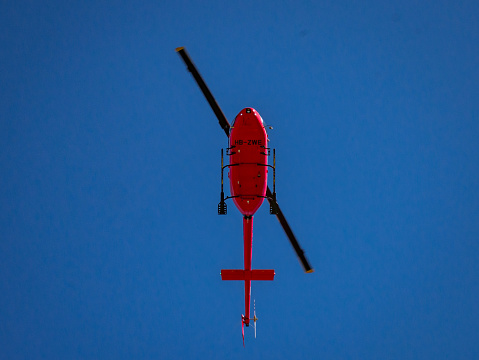 Red helicopter flying into action.