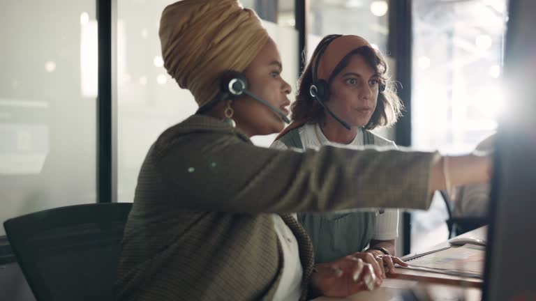 Call center, training and black woman coaching recruit at customer service agency in Africa. Diversity, teamwork and crm, telemarketing manager consulting woman at desk for customer support help line