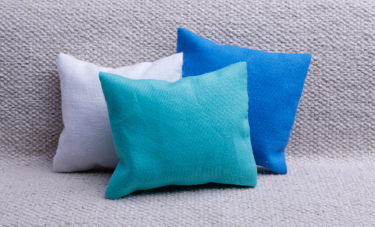 White,blue and green cushions on the gray sofa