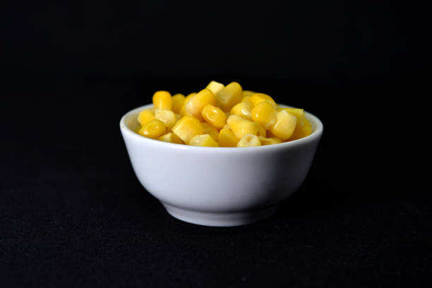 Fresh canned corn. Corn kernels in a white salad bowl. Corn in a cup.