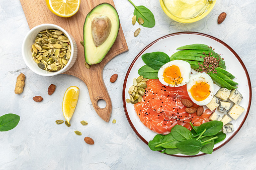 Set of diet food, salmon, avocado, cheese, egg, spinach and nuts on a light background. banner, menu, recipe place for text, top view.