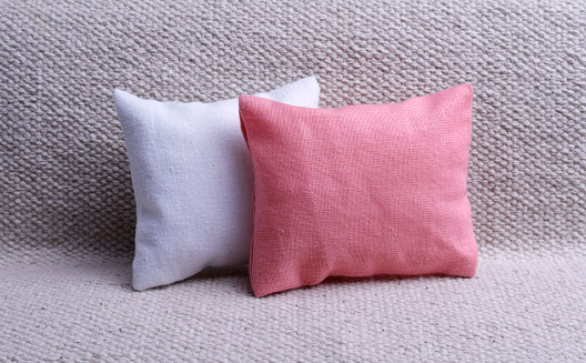 White and pink cushions on the gray sofa with copy space