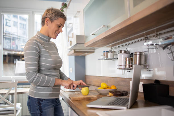 istock Mid adult woman preparing a vegetable meal using an online tutorial 1464226460