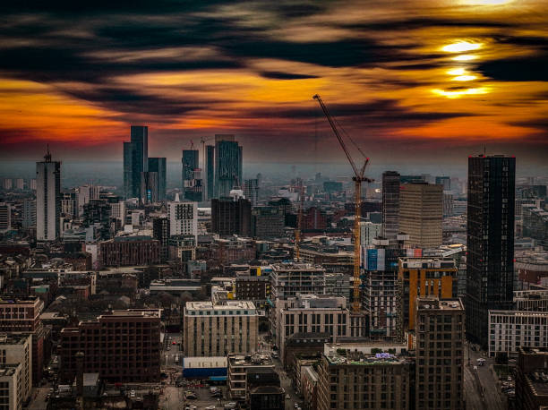Aerial photograph of Manchester City Centre at Sunset. Photograph taken in early February with low lying clouds and orange sunlight