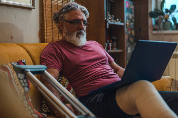 istock Mature man with broken leg in plaster cast on sofa 1464229743