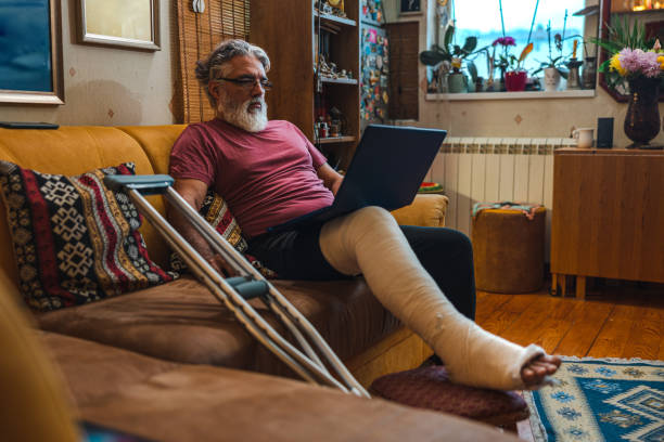 istock Mature man with broken leg in plaster cast on sofa 1464229744