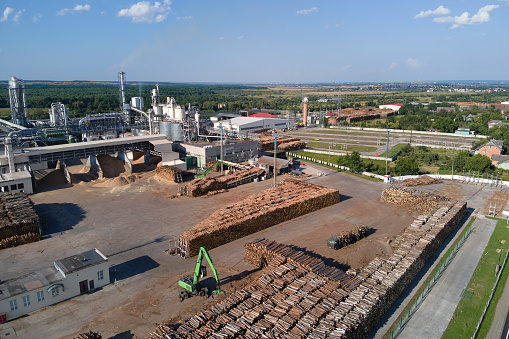 Aerial view of wood processing factory with stacks of lumber at plant manufacturing yard.