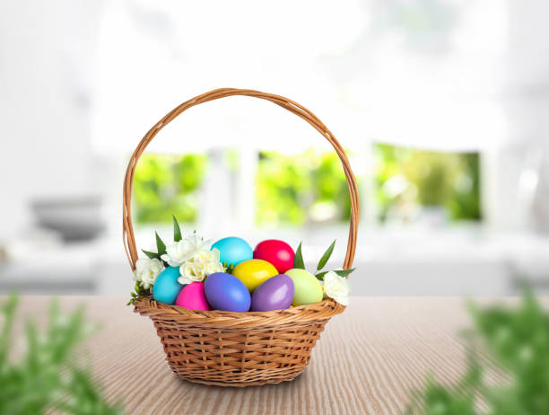 istock Wicker basket with bright painted Easter eggs and spring flowers on wooden table 1464236807