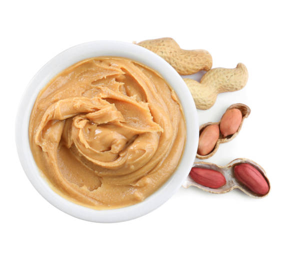 istock Delicious peanut butter in bowl isolated on white, top view 1464237528