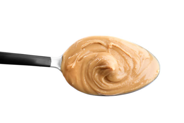 istock Delicious peanut butter in spoon isolated on white 1464237601