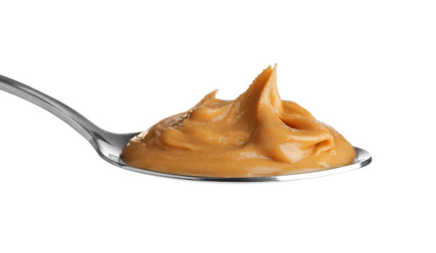istock Delicious peanut butter in spoon isolated on white 1464237633