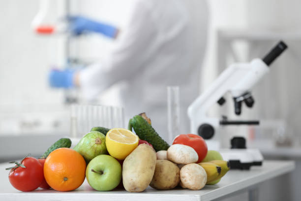 istock Fresh vegetables, fruits on table and scientist proceeding quality control in laboratory 1464238445
