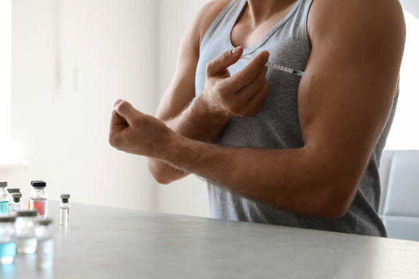 istock Athletic man injecting himself at table indoors, closeup. Doping concept 1464238605