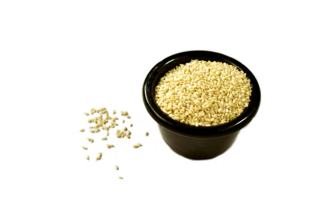 istock Sesame seeds in a black bowl on a white backgrounds 1464238860