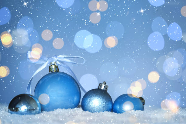 istock Beautiful light blue Christmas balls on snow against blurred festive lights, bokeh effect. Space for text 1464240071