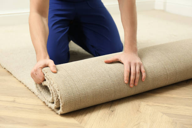istock Worker rolling out new carpet flooring indoors, closeup 1464240238