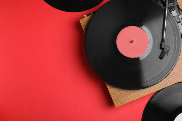 istock Modern player and vinyl records on red background, flat lay. Space for text 1464240369