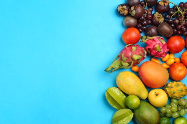 istock Assortment of fresh exotic fruits on light blue background, flat lay. Space for text 1464240805