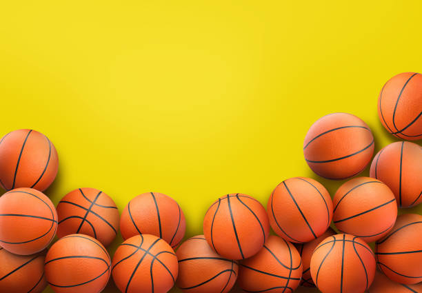 istock Many orange basketball balls on yellow background. Space for text 1464242348
