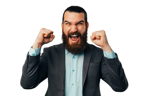 Victorious bearded screaming man wearing jacket is showing the winner gesture.