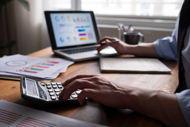 istock Business accounting concept, Business man using calculator with computer laptop, budget and loan paper in office. 1464245546