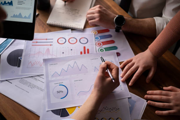 istock Group of business people meeting, discussing, analyzing graphs, financial data, and planning a marketing project together. 1464245591