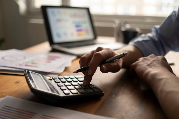 istock Business accounting concept, Business man using calculator with computer laptop, budget and loan paper in office. 1464245700