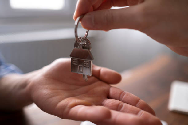 istock Real estate agent passing keys to his client 1464245834