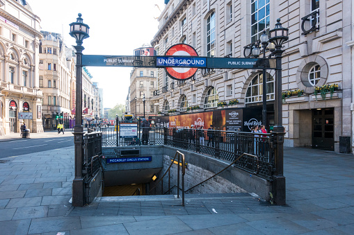 LONDON - May 20, 2022: Rail and Underground Station signs outside Waterloo Station. Train on bridge in background