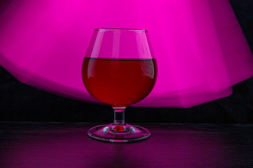 A glass of wine on a colored background