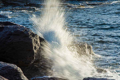 the sea of Calasetta is always rough, in this photo a wave breaks on the rocks