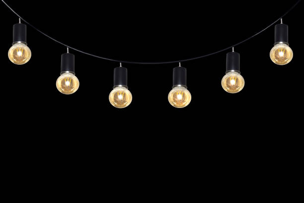 istock A row of light bulbs hanging from a wire on a black background. 1464250837