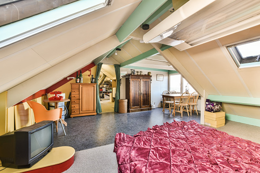 a bedroom with a bed, desk and television in the corner of the room on the left is an office