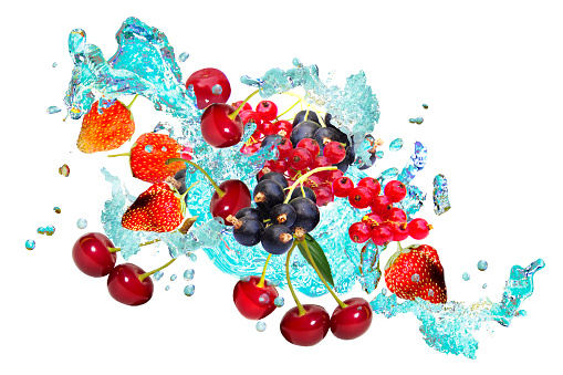 Various fresh berries flying with water in drops and splashes.