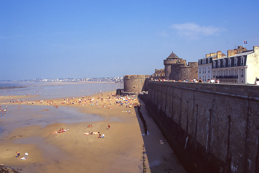 Saint Malo, Normandy, France - aug 8, 1997: the mighty fortification walls of the city of St. Malò overlook the dry beach at low tide.