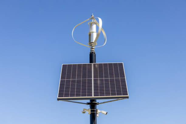 istock Small Solar Panels with Wind Turbines, front view, blue sky background with copy space 1464254506