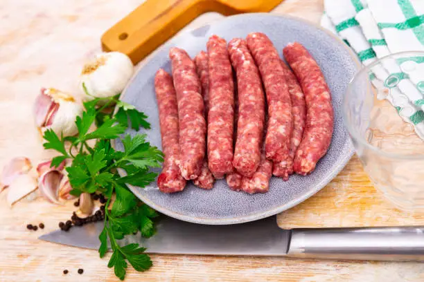 Photo of Tasty spiced longaniza, pork sausage with herbs on plate